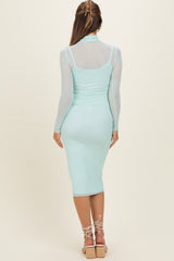 woman wearing a light blue maternity dress with a fitted silhouette and sheer long sleeves, shown from the back