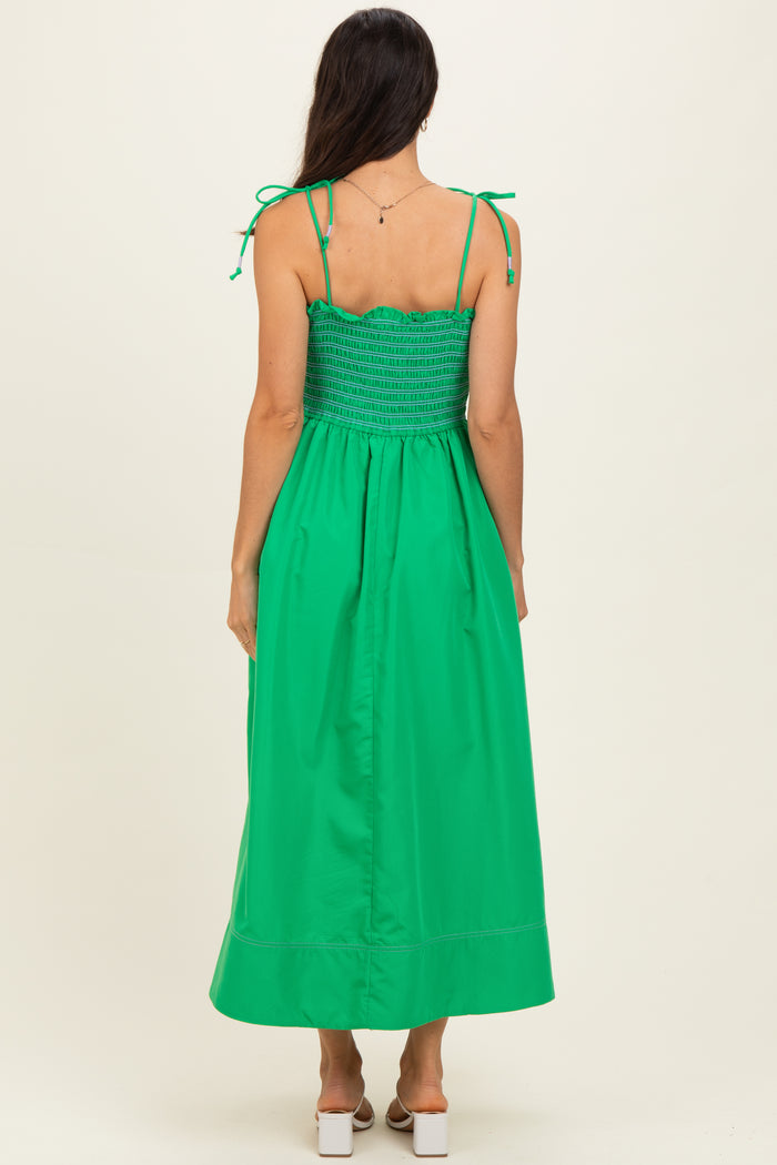 woman wearing a bright green maxi dress with adjustable tie straps and a smocked bodice visible from the back