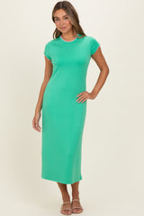 woman wearing a green short sleeve midi dress with a fitted silhouette and colorful trim details