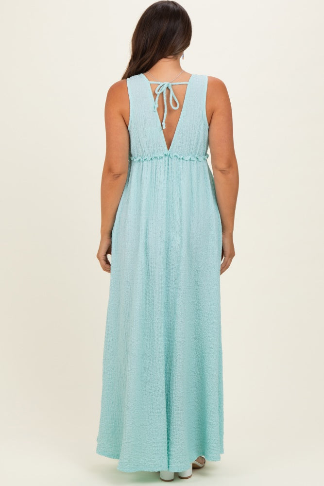 woman wearing a light blue backless maternity maxi dress with a tie detail and smocked waist