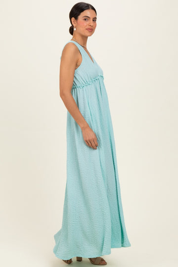 woman wearing a light blue sleeveless maxi dress with a gathered waist and flowing skirt