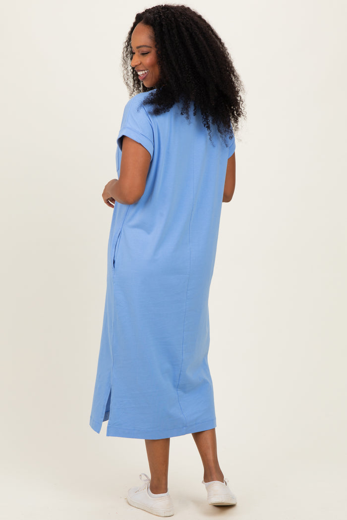 woman wearing a light blue short sleeve maxi dress, smiling and facing away from the camera