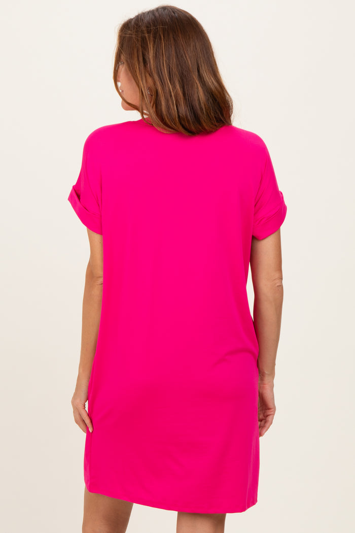 woman wearing a bright pink short sleeve dress with rolled sleeves, shown from the back