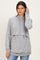 woman wearing a grey long sleeve hooded sweatshirt with a layered design and elastic hem, paired with blue jeans