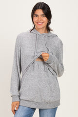woman wearing a gray hoodie with a cut-out detail and long sleeves, smiling at the camera