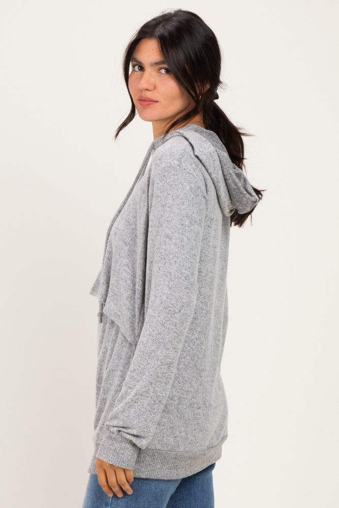 woman wearing a gray hooded cardigan with front drape detail and long sleeves, standing sideways