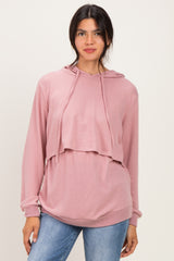 woman wearing a pink layered hoodie with long sleeves and a relaxed fit, styled over a casual top