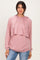 woman wearing a pink layered hoodie with long sleeves and a relaxed fit, styled over a casual top