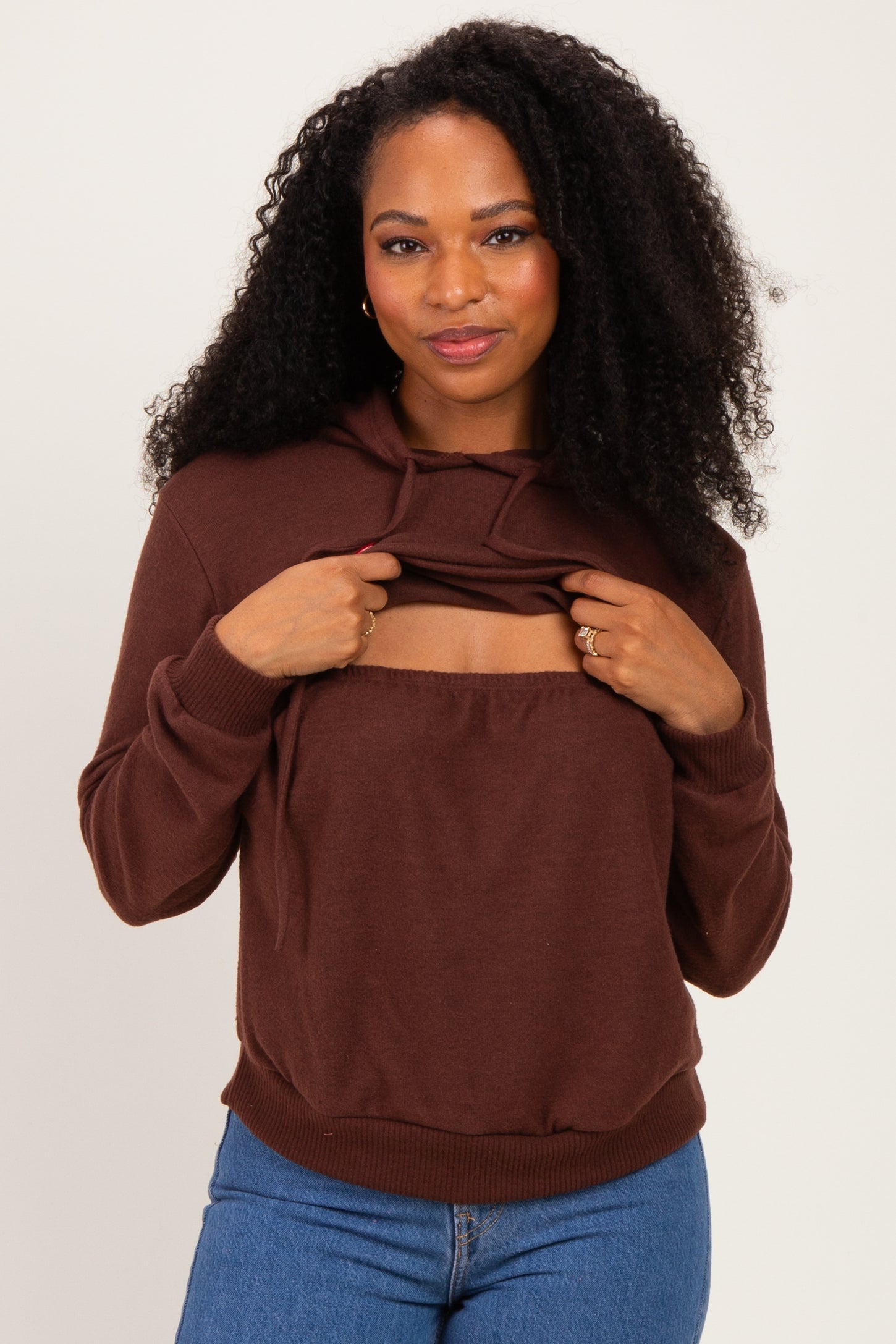 woman wearing a brown hooded sweatshirt with a scoop cutout and relaxed fit