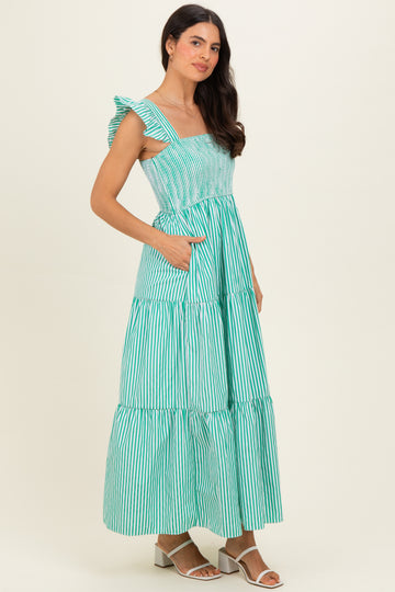 woman wearing a green and white striped maxi dress with ruffle straps and side pockets