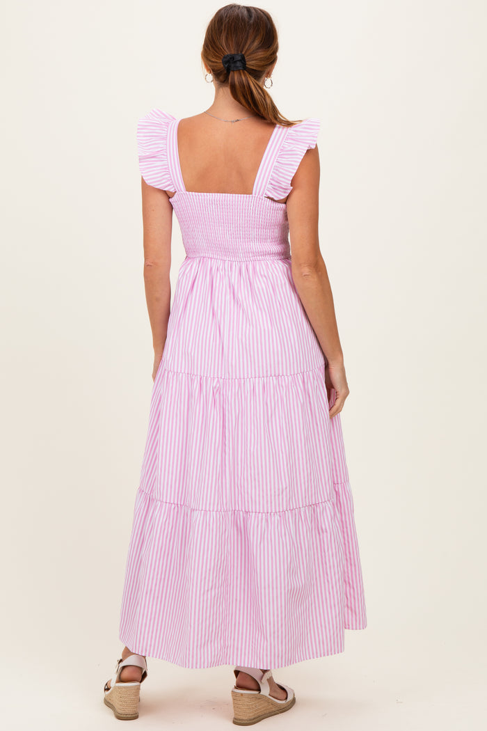 woman wearing a pink and white striped maxi dress with ruffled straps and a smocked bodice, shown from the back