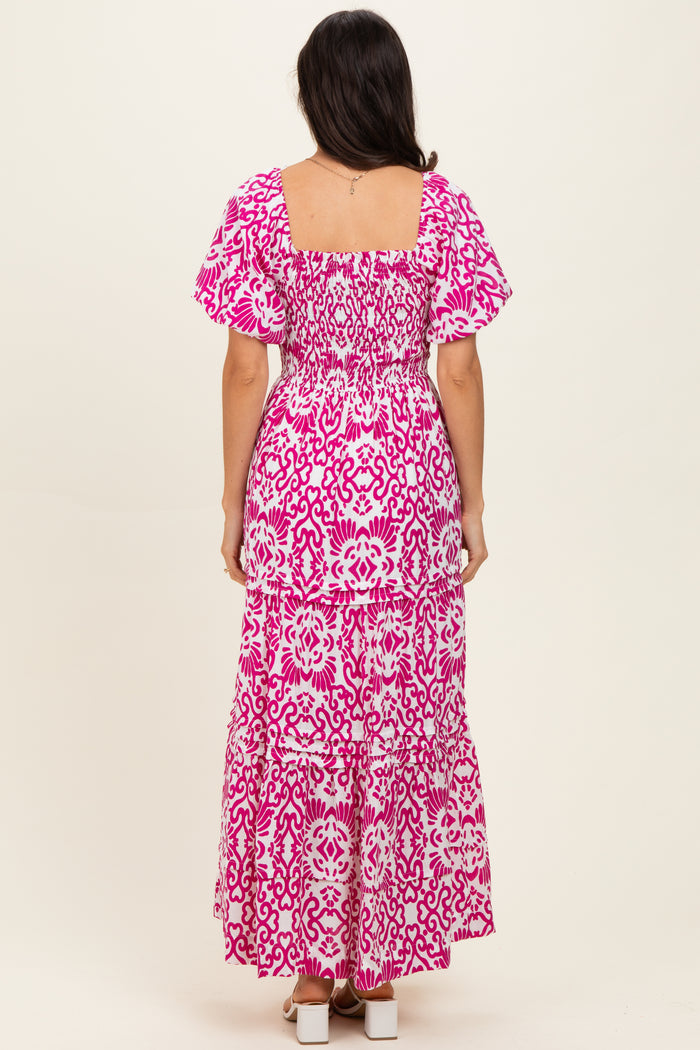 woman wearing a pink floral maxi dress with smocked bodice and tiered skirt, seen from the back