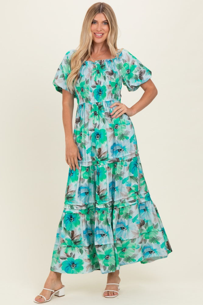woman wearing a green floral maxi dress with puff sleeves and a smocked bodice
