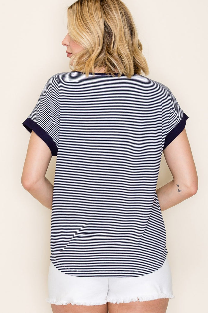 woman wearing a navy and white striped short sleeve top with contrasting dark sleeves and light denim shorts