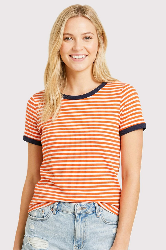 woman wearing an orange and white striped t-shirt with navy blue trim and light blue distressed jeans