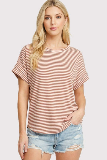 woman wearing a rust and ivory striped short sleeve top paired with distressed denim shorts
