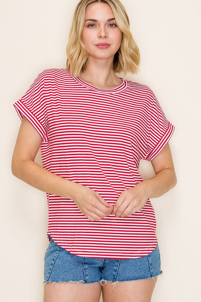 woman wearing a red and white striped short sleeve top with rolled cuffs and denim shorts