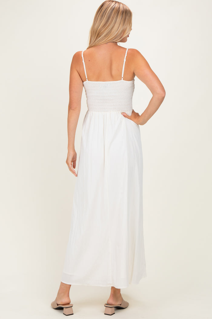 woman wearing a back view of a white maxi dress with a smocked bodice and thin straps