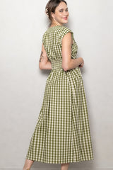 woman wearing a green and white checkered midi dress with cap sleeves and a cinched waist, smiling at the camera