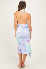 woman wearing a backless pastel abstract print maternity dress with a halter neck design