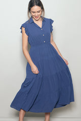 woman wearing a blue tiered midi dress with short ruffled sleeves and a button-up collar