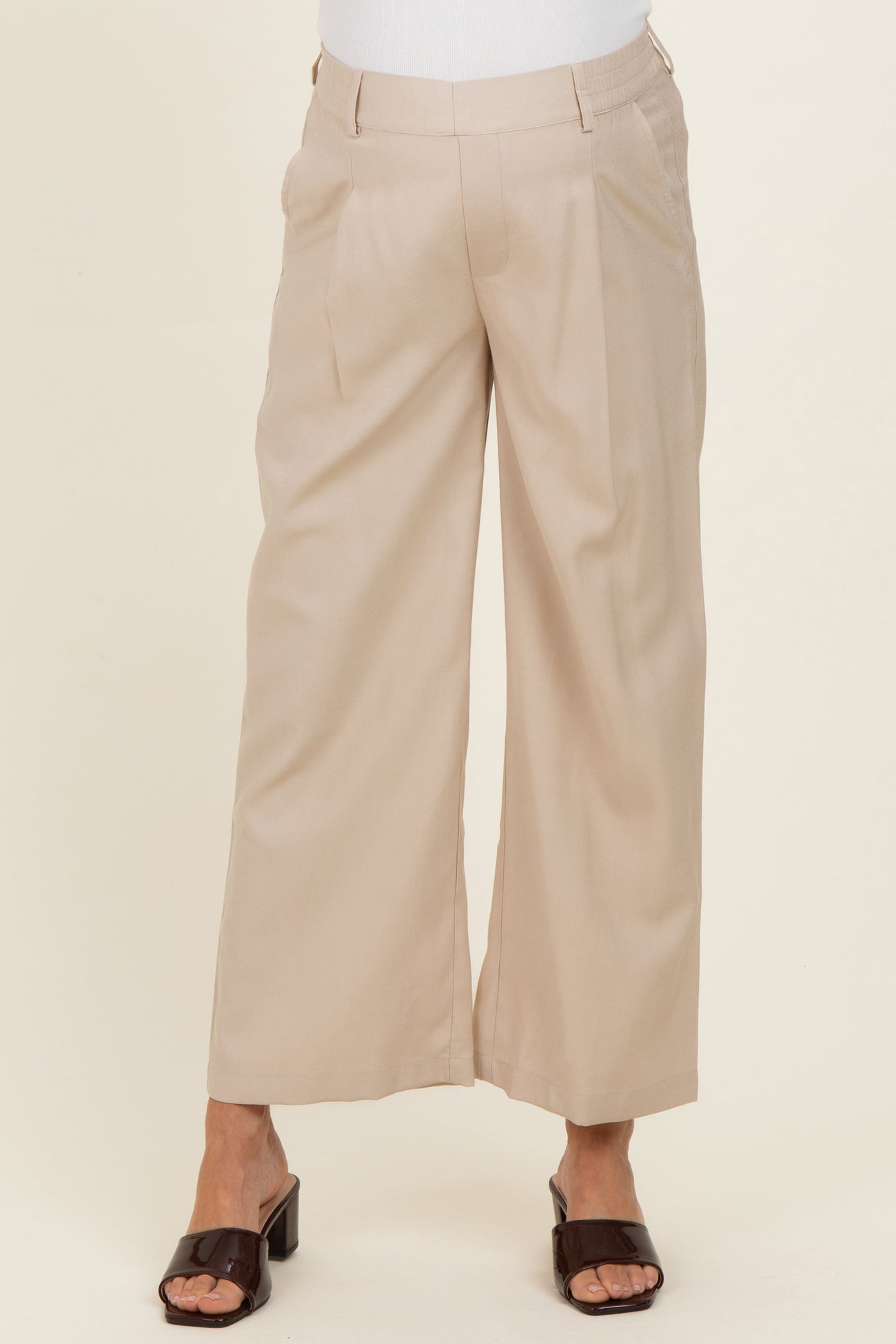 woman wearing beige wide leg maternity pants with a relaxed fit and side pockets