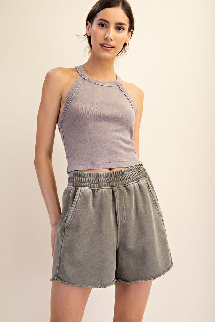 woman wearing a light gray ribbed tank top and matching high-waisted shorts with a relaxed fit