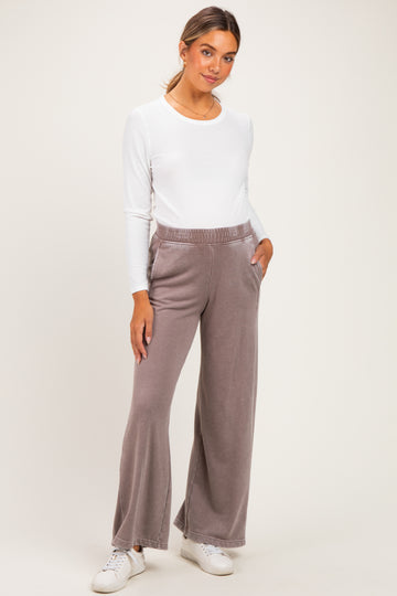 woman wearing a white long sleeve maternity top and gray wide-leg maternity pants with pockets