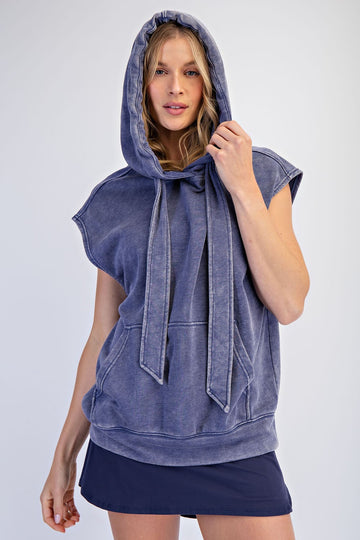 woman wearing a navy blue sleeveless hoodie with a drawstring hood and front pocket