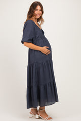 woman wearing a navy checkered maternity dress with tiered skirt and baby bump visible