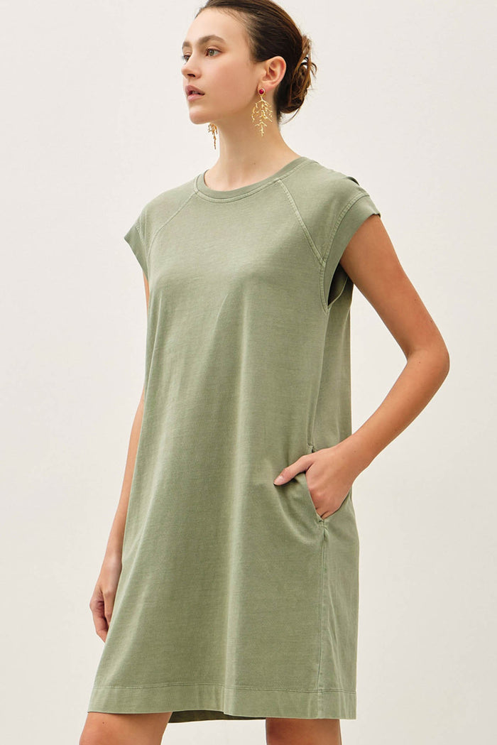 woman wearing a green short sleeve casual dress with side pockets and a relaxed fit