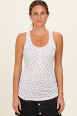 woman wearing a white maternity tank top with small floral print and button details