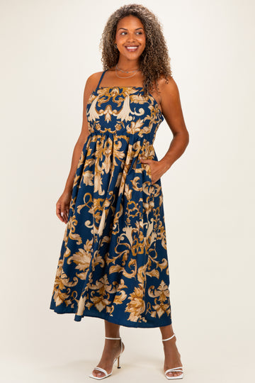 woman wearing a navy blue floral print plus size maxi dress with pockets and adjustable straps