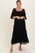 woman wearing a black lace maternity maxi dress with three-quarter sleeves and a smocked bodice, holding her baby bump