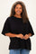 woman wearing a black oversized t-shirt with short sleeves and a relaxed fit, smiling at the camera