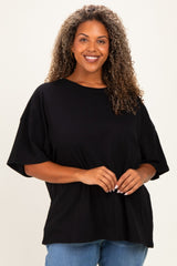 woman wearing a black oversized t-shirt with short sleeves and a relaxed fit, smiling at the camera