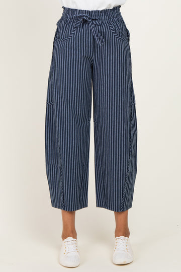 woman wearing navy blue striped wide-leg trousers with a tied waist and side pockets