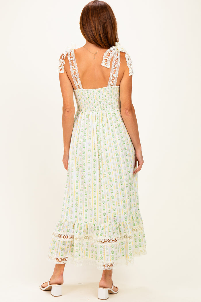 woman wearing a back view of a white floral maxi dress with lace details and adjustable straps