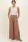 woman wearing a tan wide-leg pant with pockets and a white sleeveless top