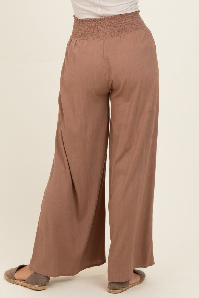 woman wearing brown wide-leg pants with a smocked waistband, viewed from the back