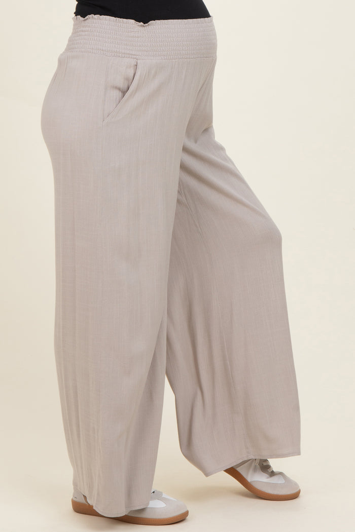 maternity wear light beige wide-leg pants with an elastic waistband and side pockets, worn by a model with a baby bump