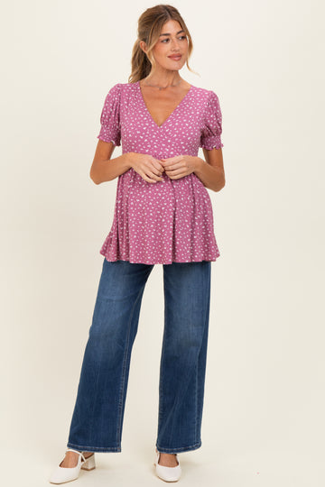 woman wearing a pink polka dot maternity top with a v-neck and puff sleeves, paired with wide-leg jeans and showing a baby bump