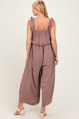 woman wearing a dusty rose maternity jumpsuit with ruffle straps and wide legs, showing a baby bump
