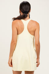 woman wearing a light yellow sleeveless dress with a racerback style and a relaxed fit
