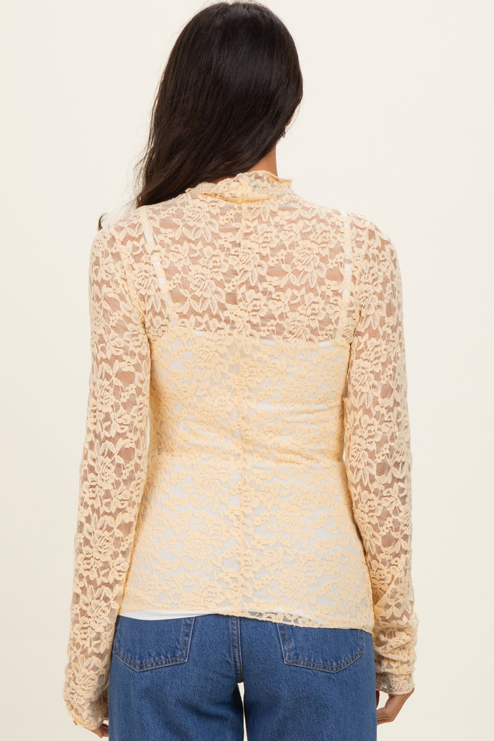 back view of a woman wearing a sheer yellow lace long sleeve top over a fitted bodice with a casual style
