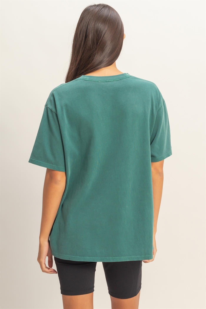woman wearing a green oversized t-shirt with a relaxed fit and short sleeves, viewed from the back