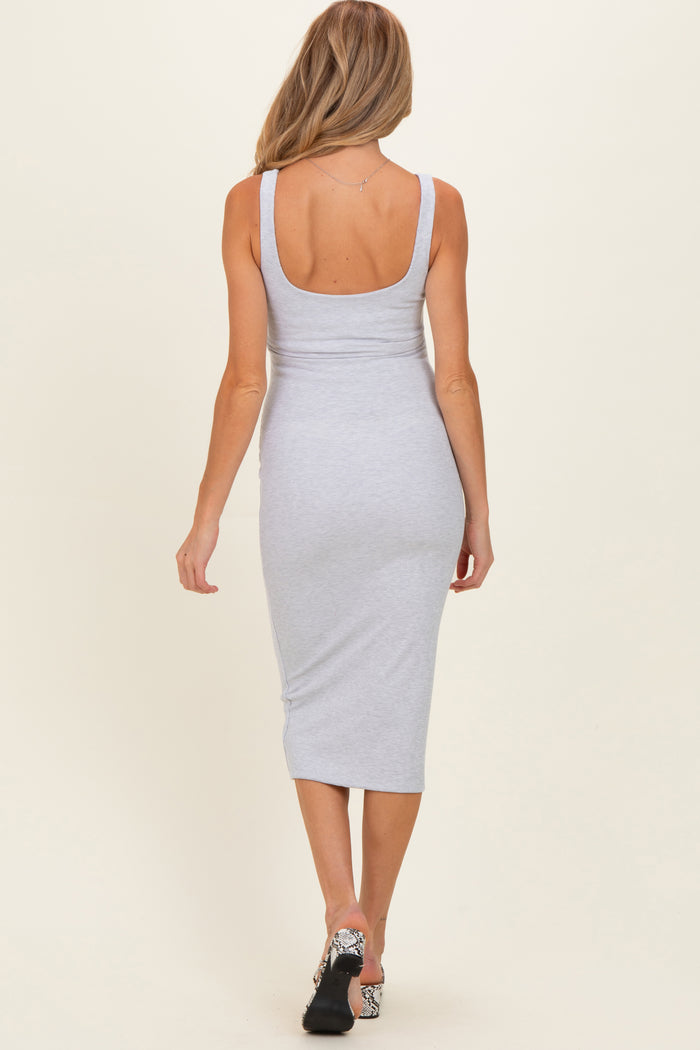woman wearing a light grey sleeveless midi maternity dress, showing a fitted silhouette from the back