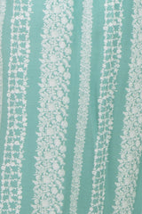 maternity wear in a turquoise fabric with white floral and stripe patterns
