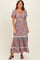 woman wearing a colorful floral maxi dress with short flutter sleeves and a tiered skirt