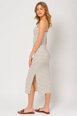 woman wearing a cream and black striped midi dress with a side slit and spaghetti straps